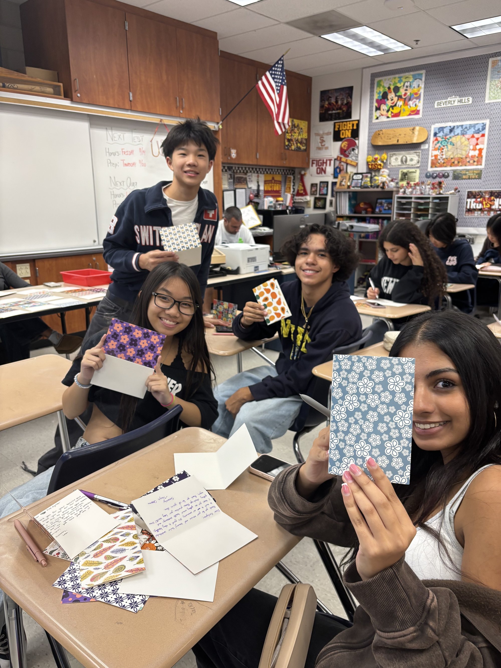 Students holding handmade cards in a classroom