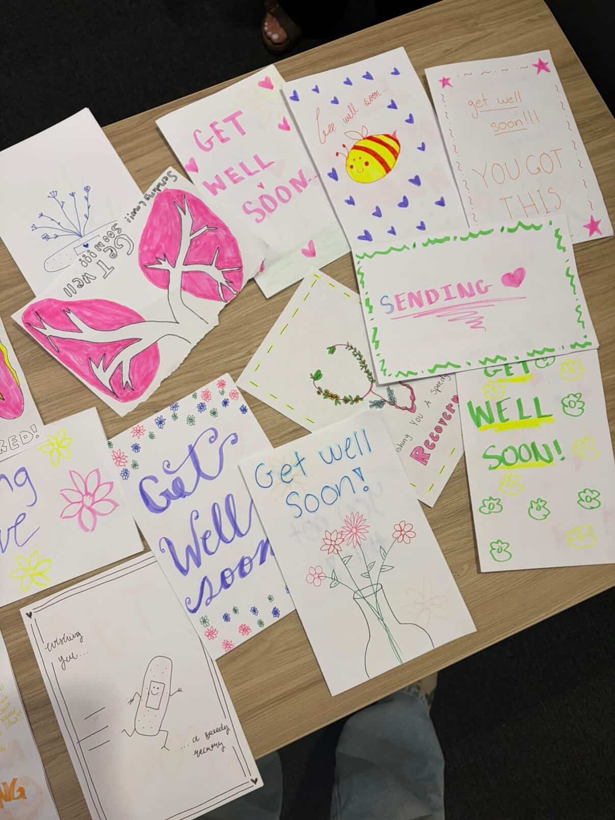 Handwritten get-well cards laid out on a table
