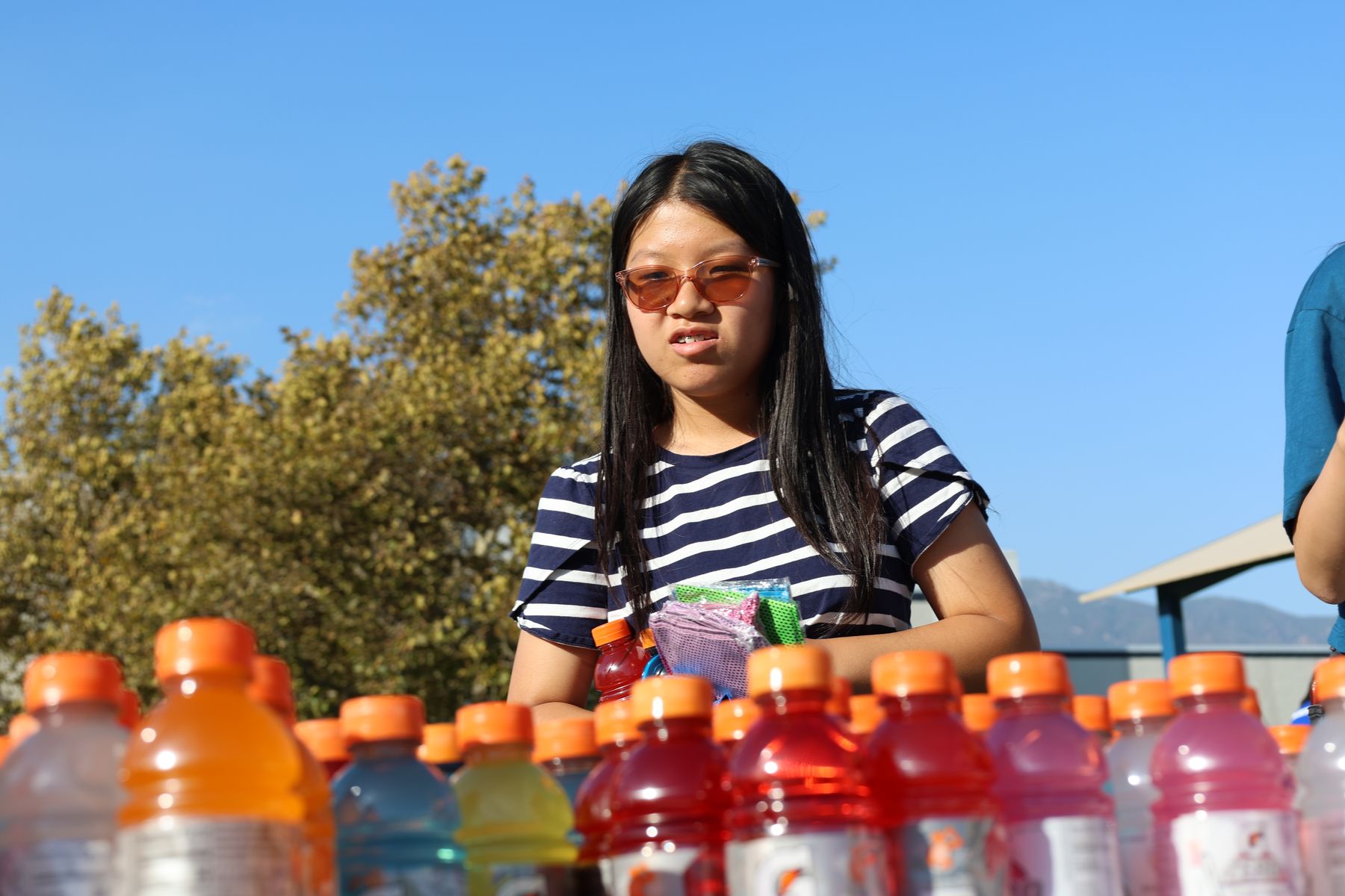 A volunteer beside a table of sports drinks