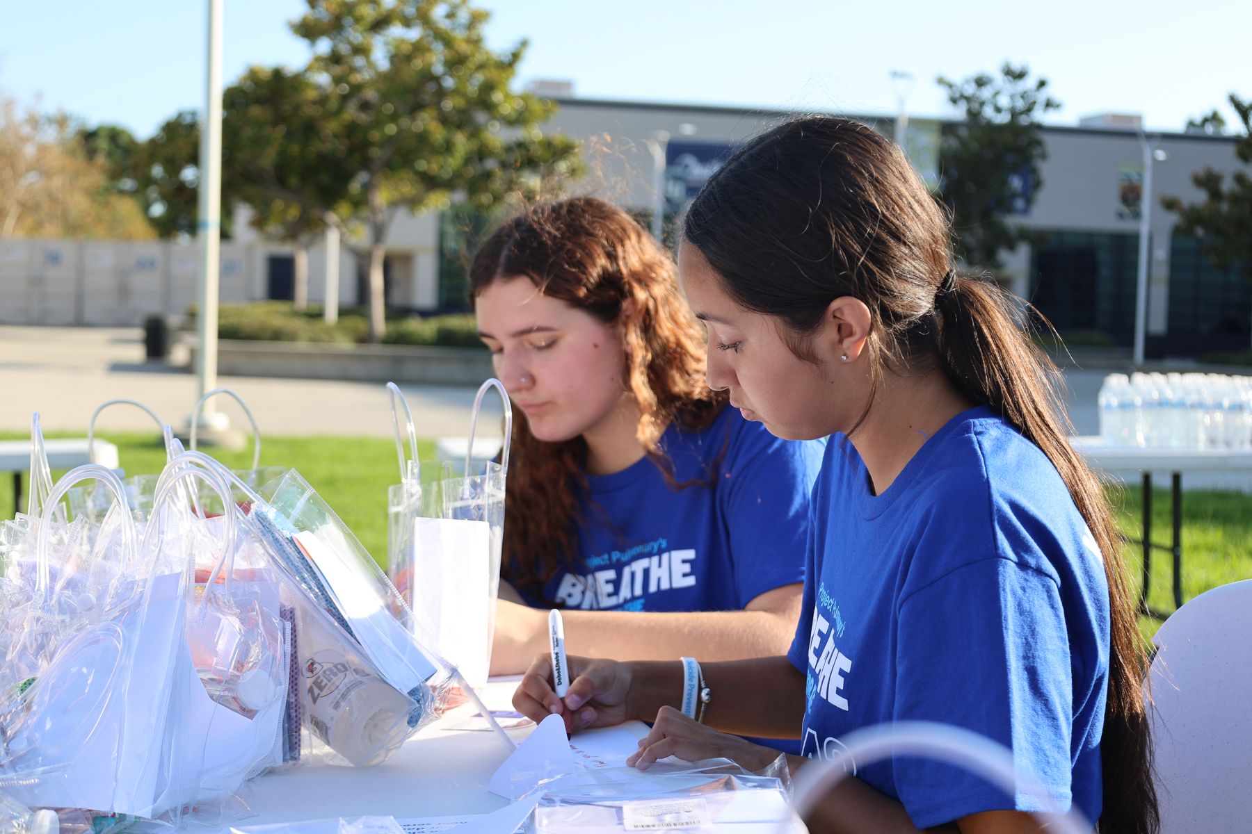 Two volunteers packing kits at a table