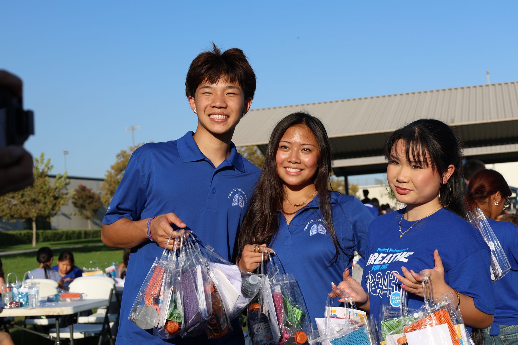 Three volunteers holding finished kits