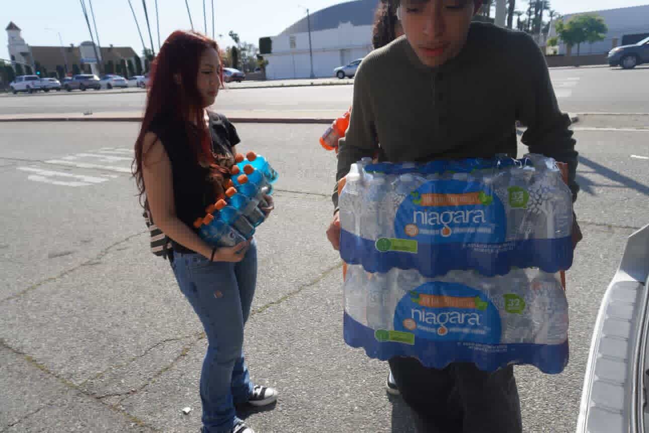 Volunteers carrying cases of water