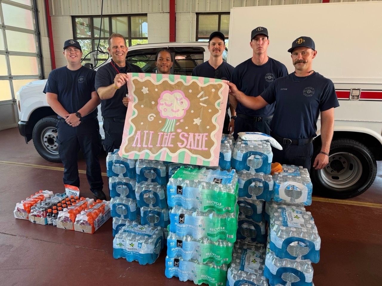 A fire crew with donated water and a thank-you poster