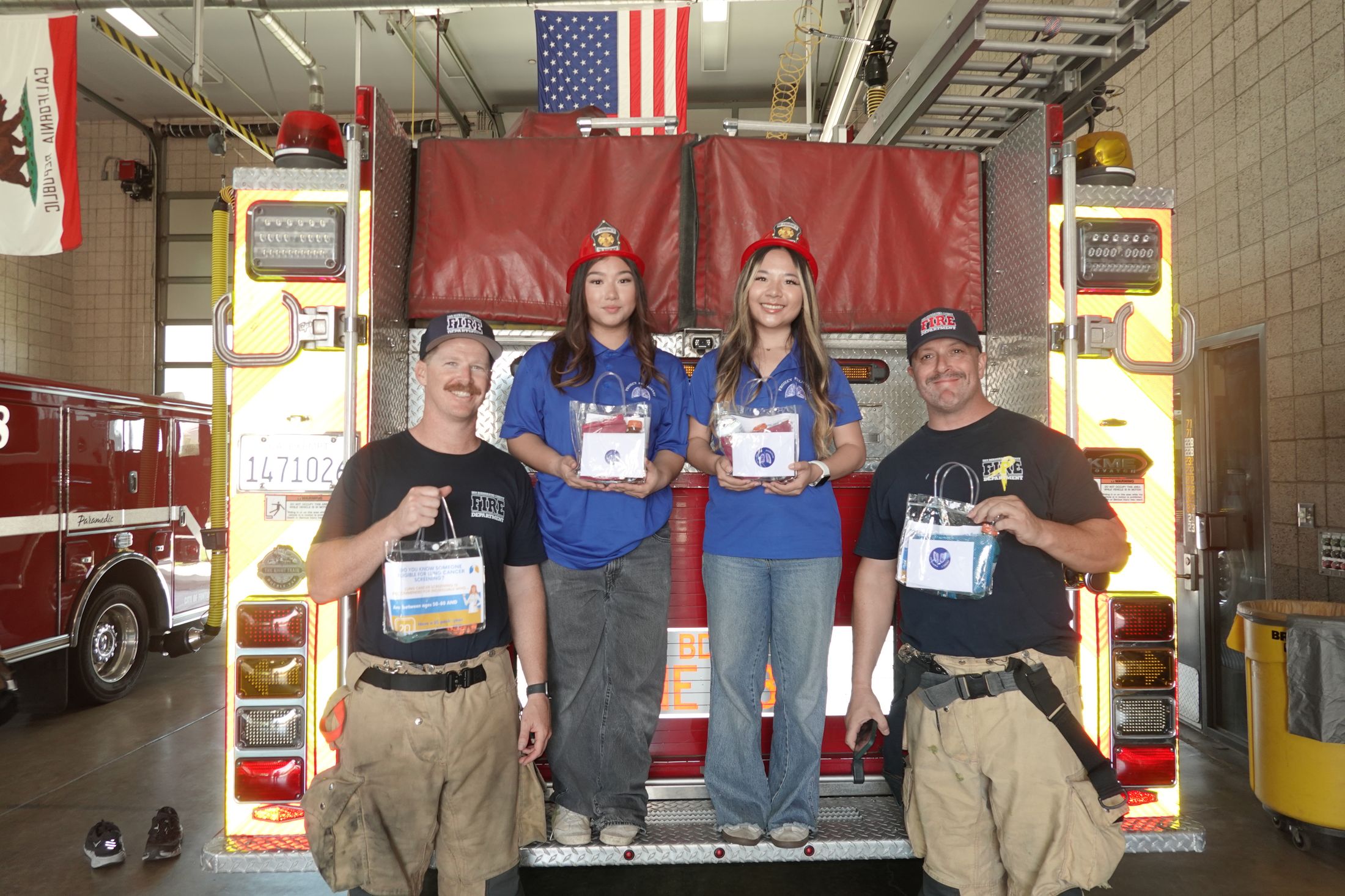 Firefighters and students holding letters under the flag