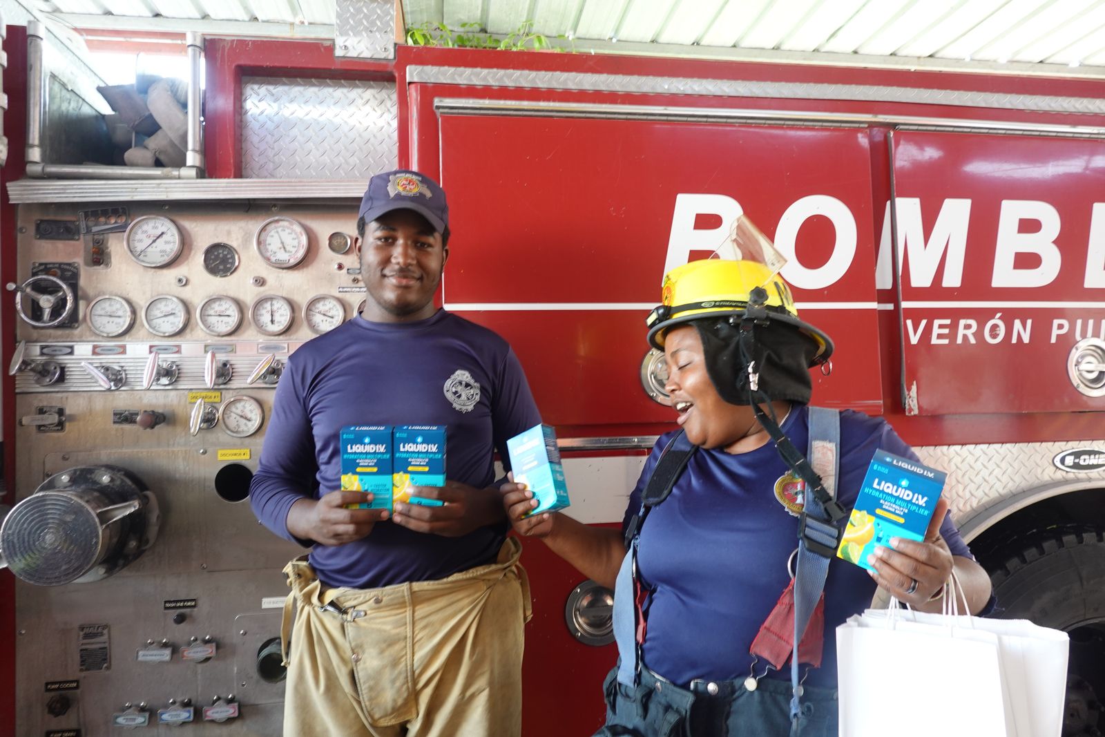 Bomberos in the Dominican Republic holding donated hydration packs