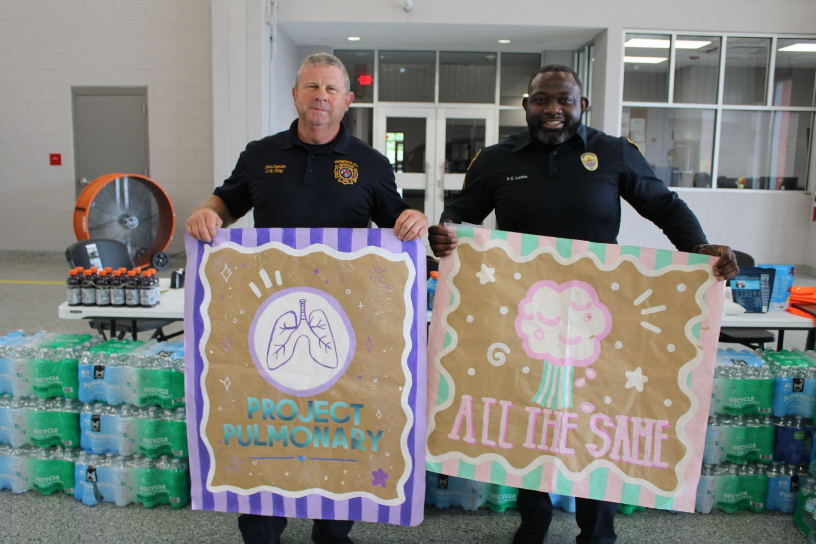 Firefighters holding Letters for Lungs posters from Project Pulmonary students