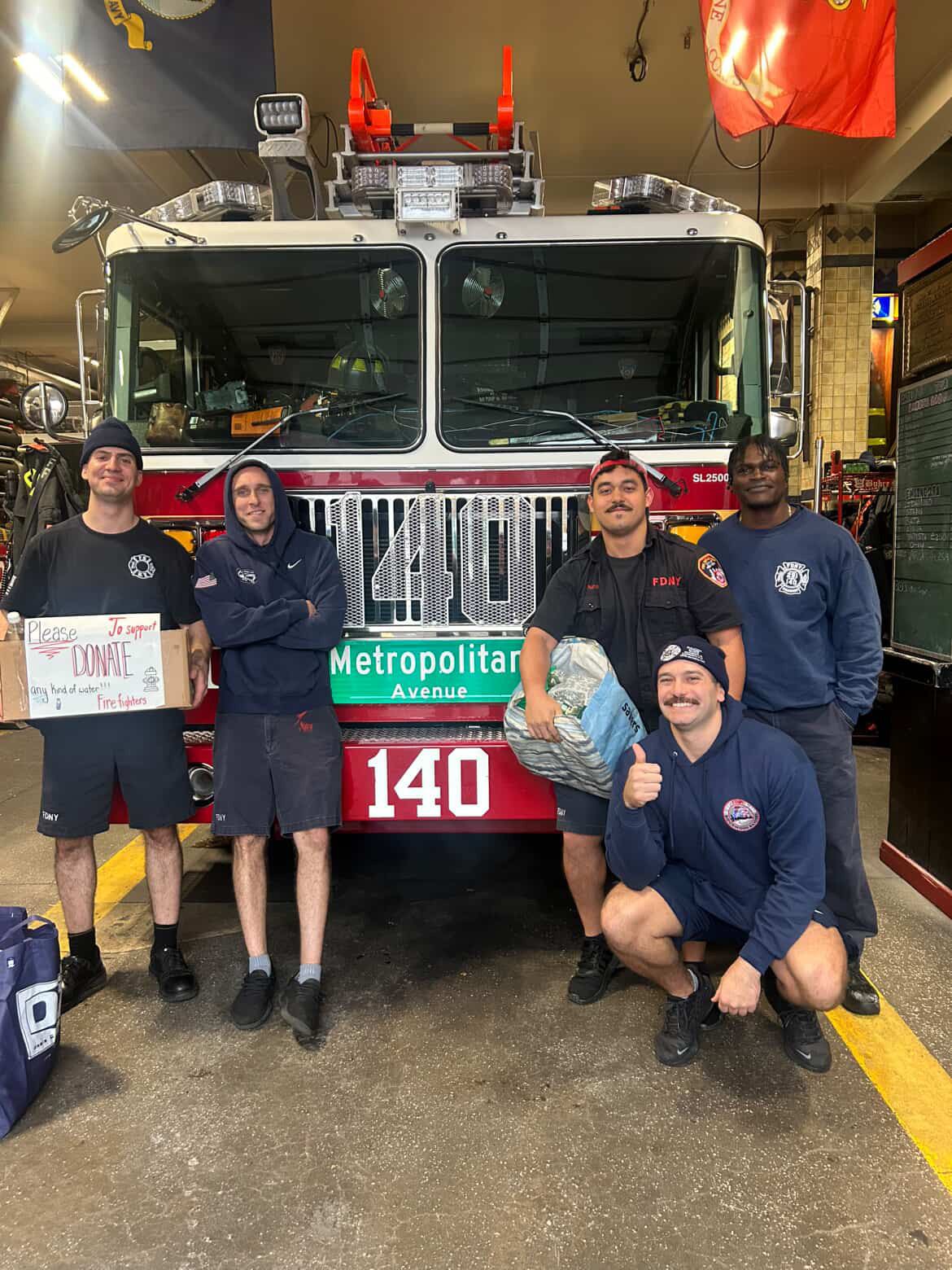 FDNY Engine 140 firefighters with a water donation drive box