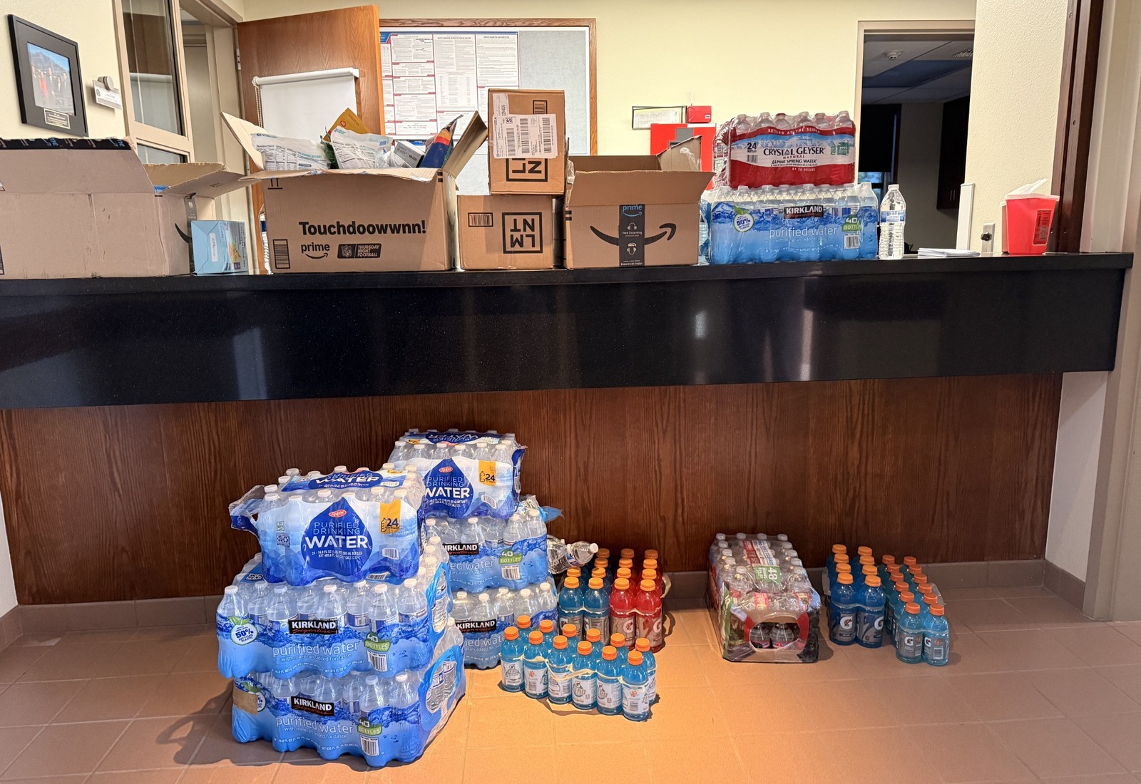 Firefighters and Project Pulmonary volunteers holding hydration products in a station