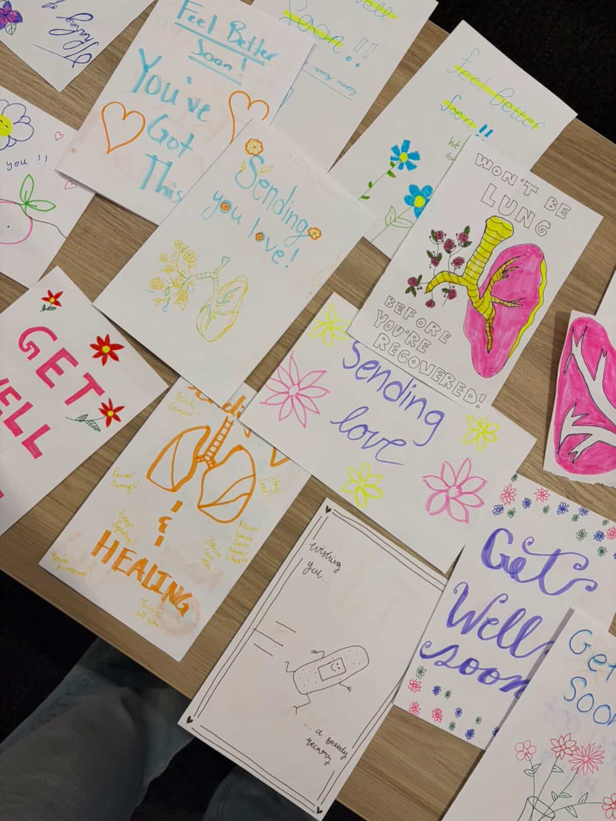 Handwritten get-well and encouragement cards laid out on a table