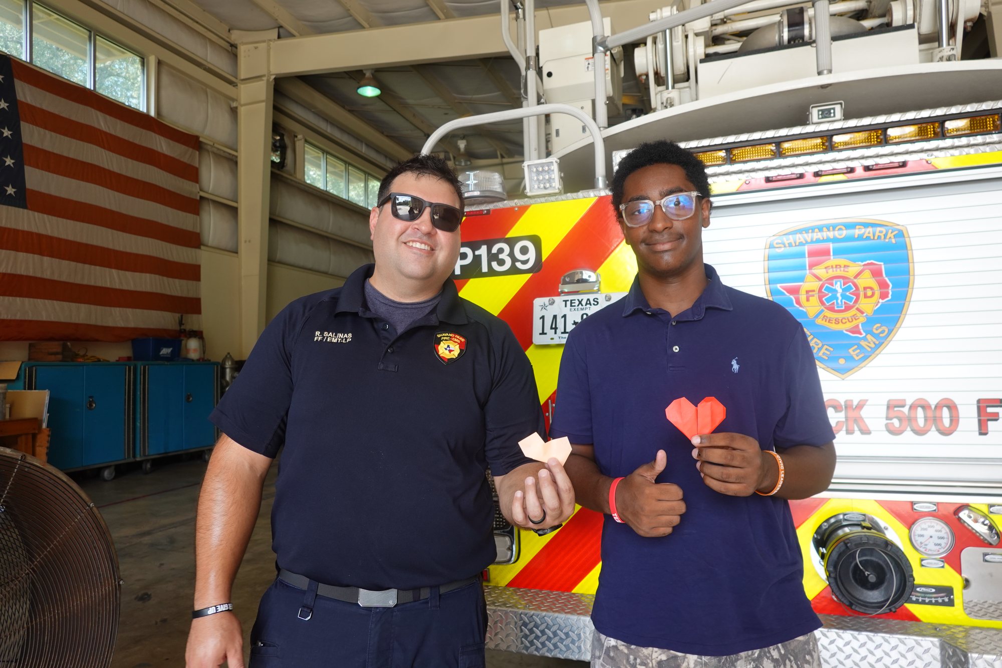 Shavano Park firefighter and student holding origami hearts