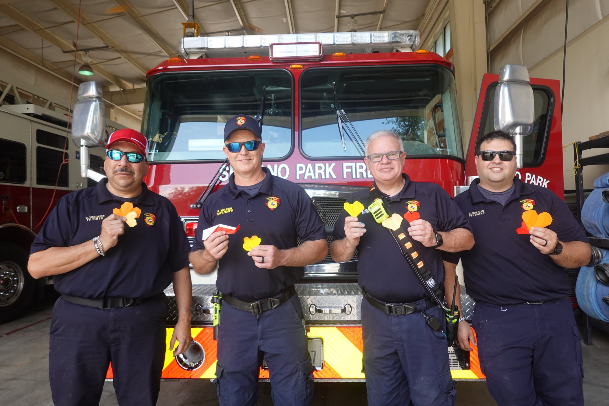 Shavano Park firefighters holding origami hearts made by Project Pulmonary students
